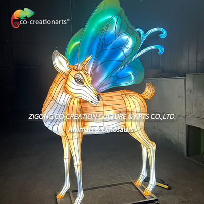 Фонарь на фестивале волшебных оленей с ярко-голубовато-зелеными крыльями бабочки.